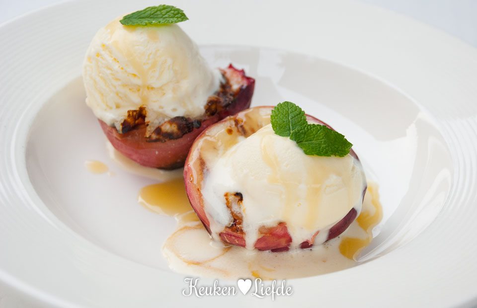 Gegrilde perzik met vanille-roomijs en karamelsaus Gegrilde perzik met vanille-roomijs en karamelsaus