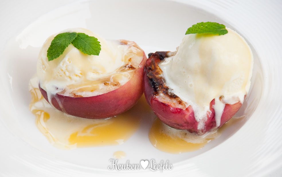 Gegrilde perzik met vanille-roomijs en karamelsaus Gegrilde perzik met vanille-roomijs en karamelsaus