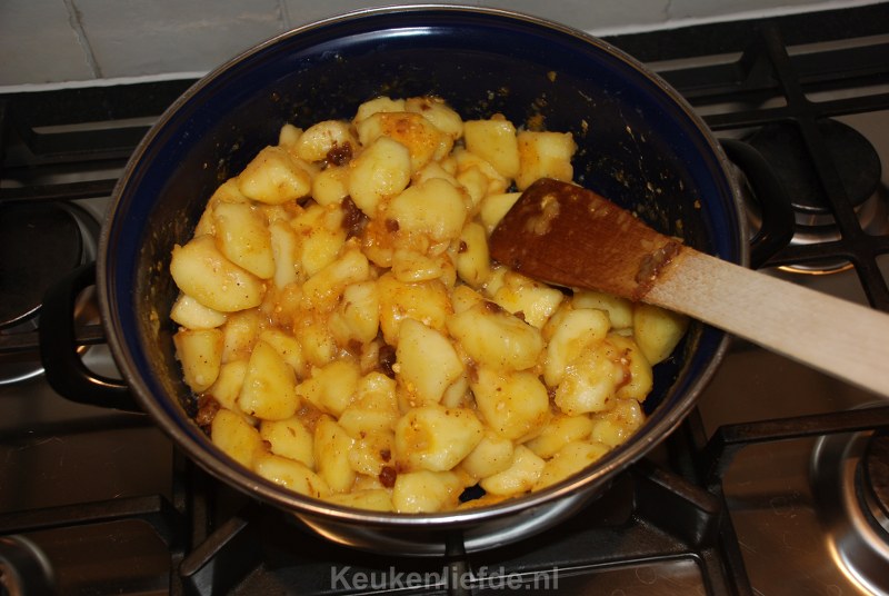 Roer de rozijnen, suiker, kaneel en custard door de appels