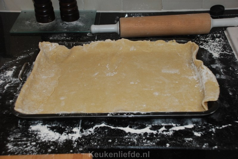 Bekleed het bakblik met het deeg