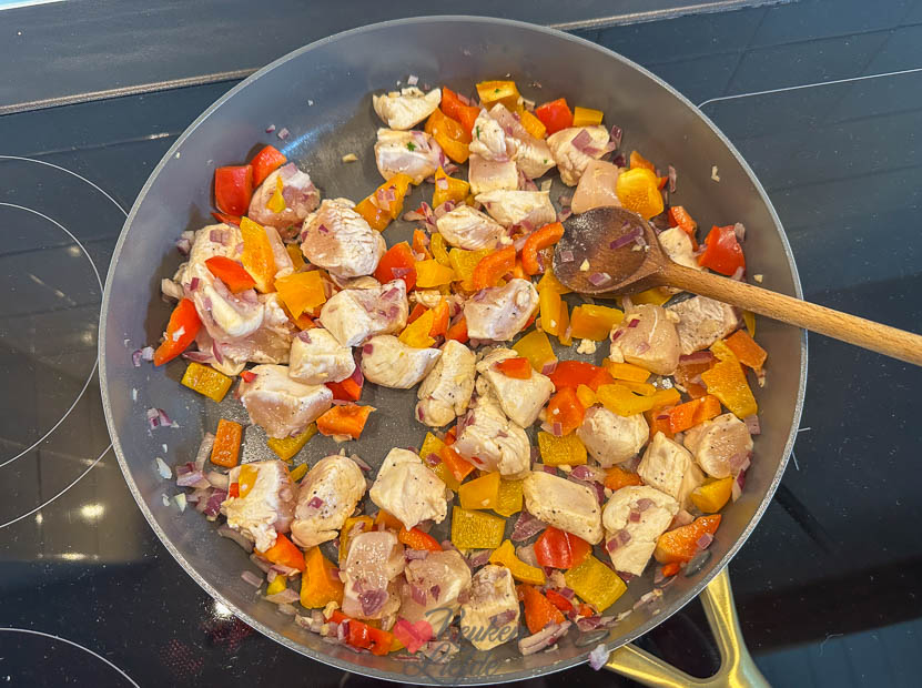 Bak de kip, paprika, ui en knoflook