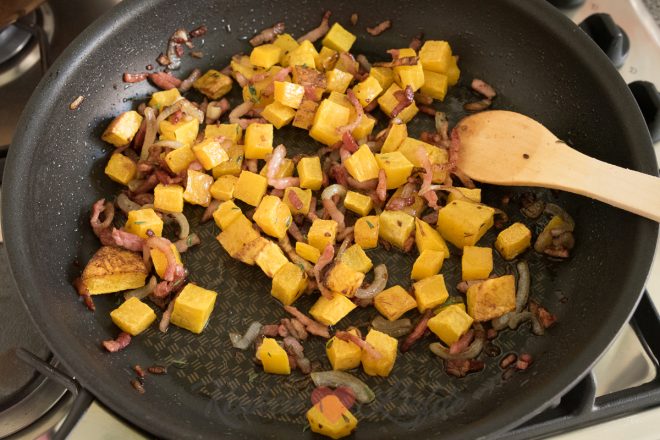 Roer de pompoenblokjes door het spek en de ui.