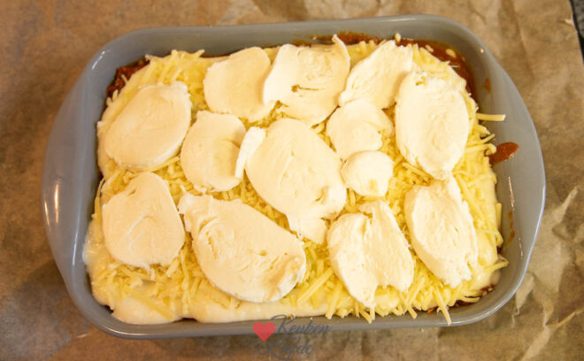 Bouw lagen saus en lasagnebladen op in de ovenschaal.