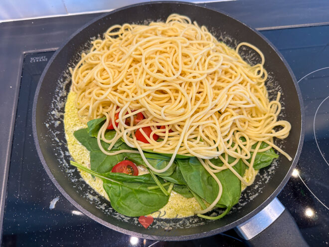 Roer de spaghetti door de saus