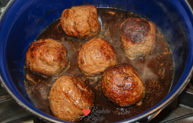 Laat de gehaktballen zachtjes garen in de fond