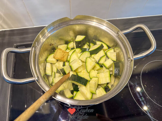 Voeg de courgette en bouillonblokjes toe