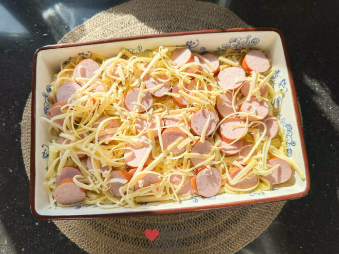 Verdeel rookworst en kaas erover