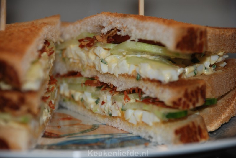 Club sandwich met eiersalade, bacon en komkommer
